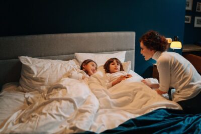 Nanny Sharing Bed Time Story With Two Children