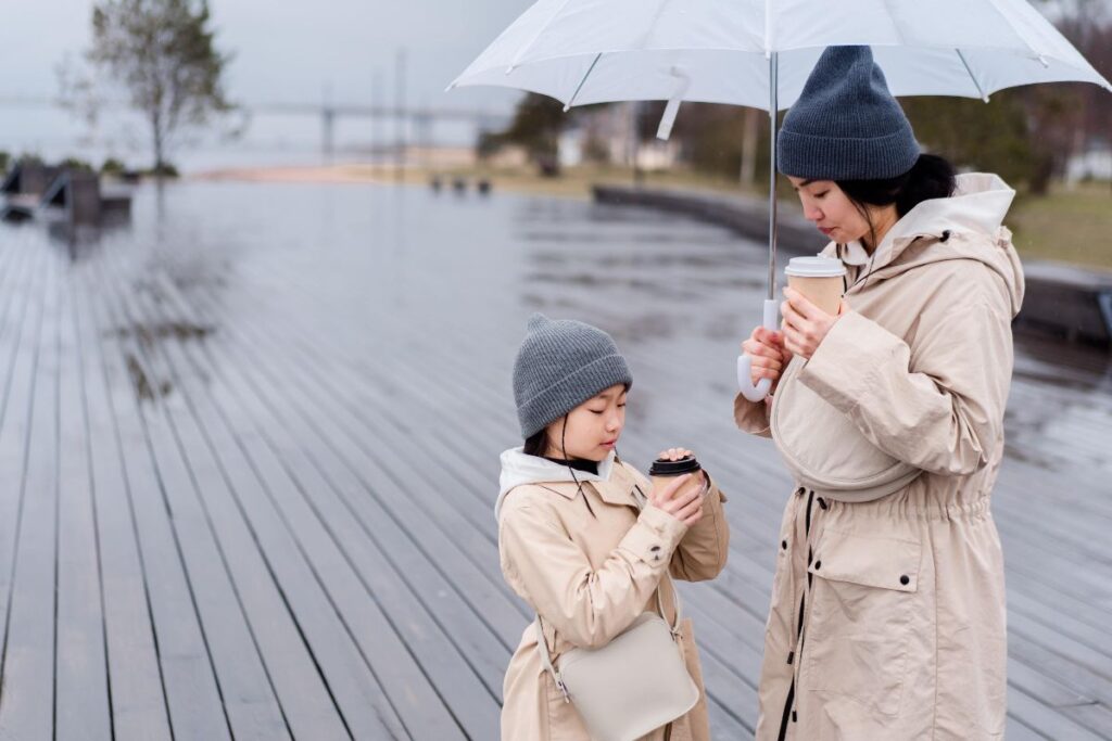 Mom And Child Having Hot Beverage In Rain