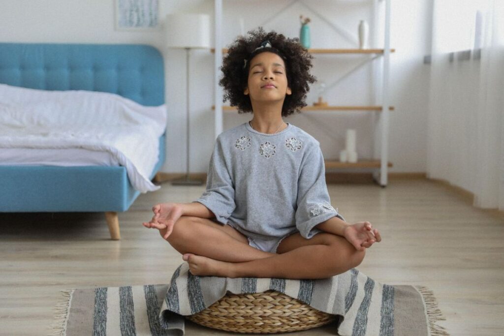 Child Meditating On The Floor