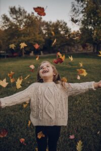 Kid Playing With Leaves During Fall