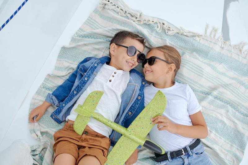 Children Lying Down On A Towel On A Yacht