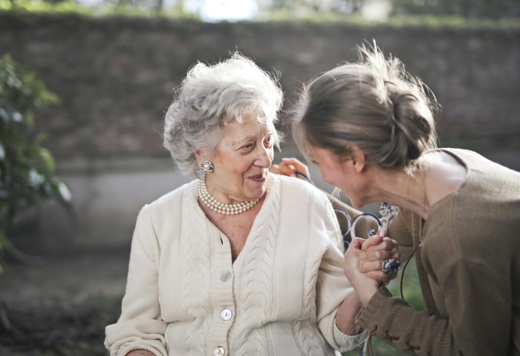 Caregiver Gently Holding Hands With An Elderly Person With Dementia