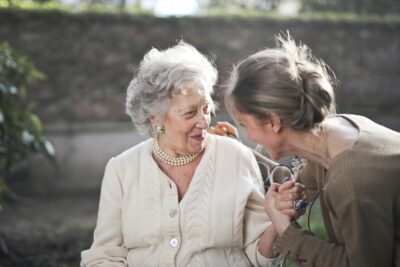 Caregiver Gently Holding Hands With An Elderly Person With Dementia