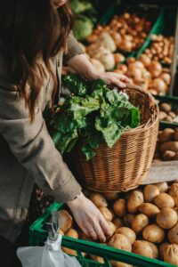 Individual Selecting Potatoes Into A Woven Basket