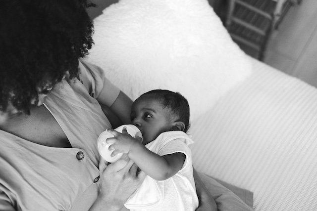 Newborn Care Specialist Feeding Baby With A Bottle