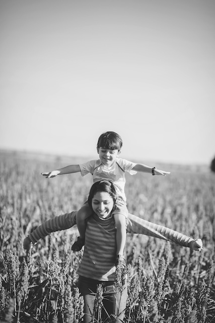 Child Sitting On Nanny’s Shoulders In Field In Chicago Suburbs