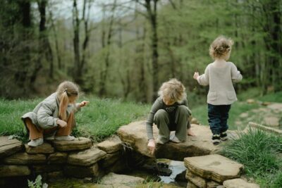 Children Exploring Creek With Sticks During Free Play