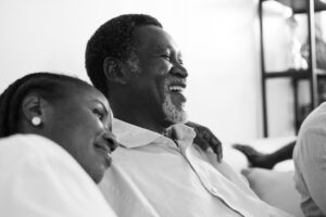 Adult Daughter With Arm Around Smiling Elderly Father