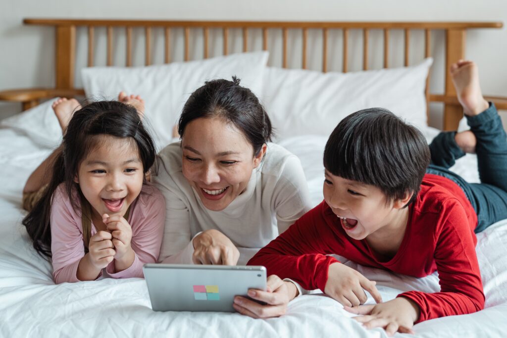 Adult And Children Looking At Educational App On Tablet