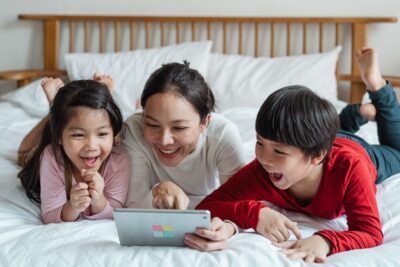 Adult And Children Looking At Educational App On Tablet
