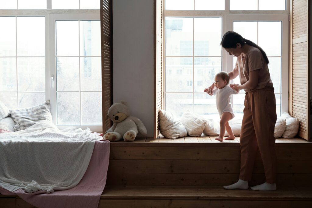 Nanny Assisting Toddler With Walking